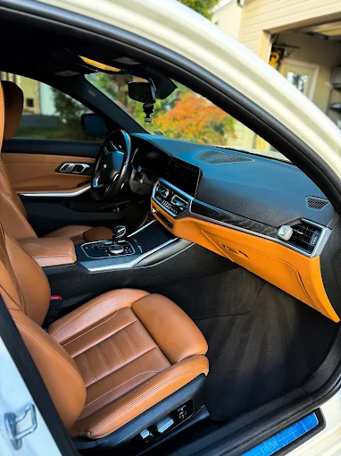 BMW interior with tan leather seats and carbon trim cleaned and conditioned by Constable Car Detailing